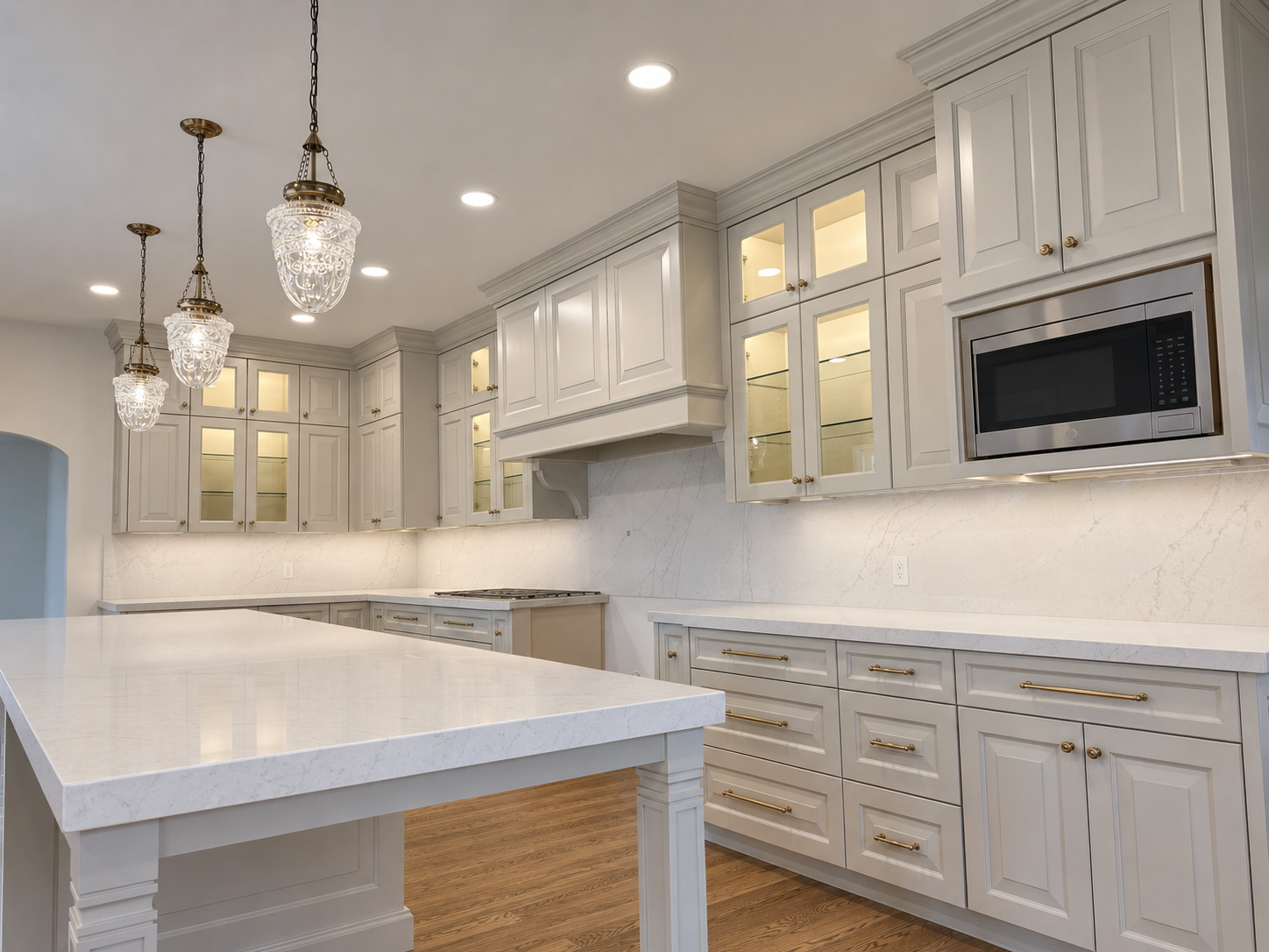 Luxury kitchen featuring warm white LED lighting inside glass display cabinets and beneath upper cabinets.